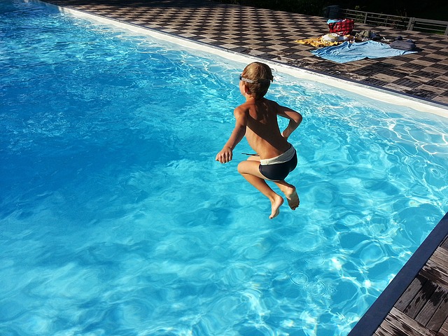 dítě jak skáče do bazénu